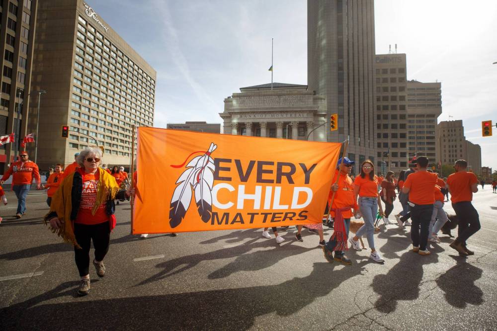 Hundreds of people take part in the march towards the RBC Convention Centre from The Forks Friday morning. (Mike Deal / Winnipeg Free Press)