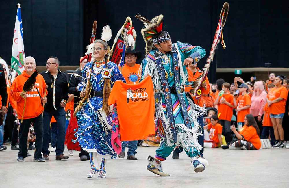 Sherry Starr and Wab Kinew lead the grand entrance at the second annual Orange Shirt Day Survivors Walk and Pow Wow on National Day for Truth and Reconciliation in Winnipeg on Friday. (John Woods / The Canadian Press)