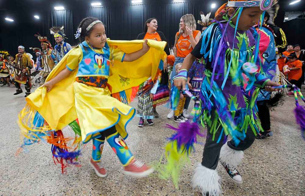 Hannah Lavallee, 6, and brother Tyee, 8, dance during the grand entrance at the second annual Orange Shirt Day Survivors Walk and Pow Wow on National Day for Truth and Reconciliation in Winnipeg. (John Woods / The Canadian Press)