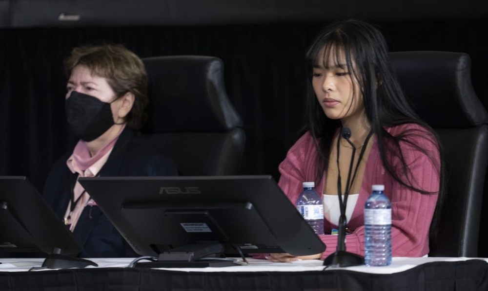 Victoria De La Ronde, left, and Zexi Li, the first witnesses to appear at the Public Order Emergency Commission, react as audio of truck horns from the protest is played during their testimony, in Ottawa, Friday, Oct. 14, 2022. THE CANADIAN PRESS/Adrian Wyld