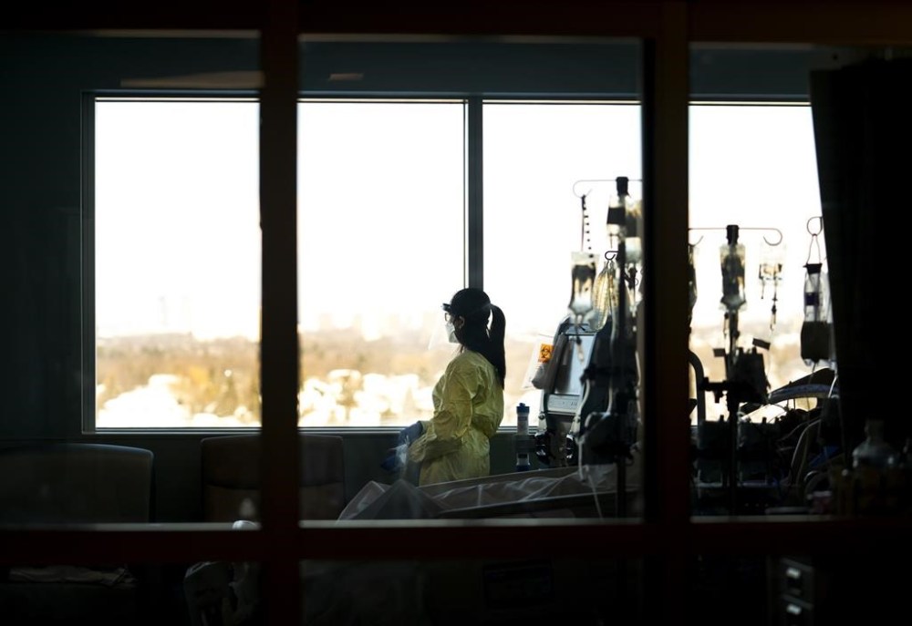 A registered nurse takes a moment to look outside while attending to a ventilated COVID-19 patient in the intensive care unit at the Humber River Hospital, in Toronto, Jan. 25, 2022. Canada's health ministers are set to meet in British Columbia this week, four months after premiers from across the country converged on Victoria to show a united front of frustration over what they called a