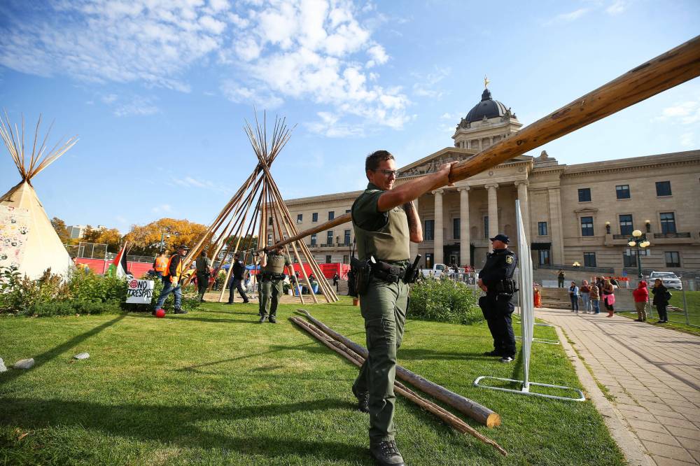 MIKE DEAL / WINNIPEG FREE PRESS
Officers remove a teepee from the grounds.