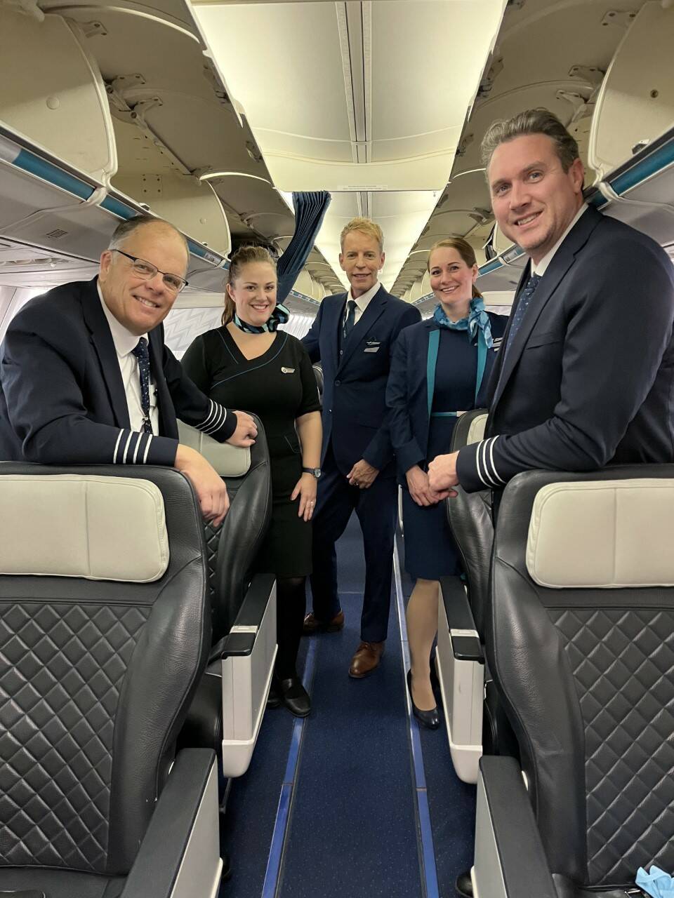Andrew Minard (far left) and Thad Lankester (far right) co-piloted the inaugural direct flight between Winnipeg and Los Angeles Monday morning. Between the two, are cabin crew members Mélanie Kennedy (from left), Ian Carter and Stephanie Catteeuw. (Gabrielle Piché / Winnipeg Free Press)