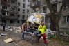 Medics carry the lifeless body of a victim found under rubble at the scene of night shelling in Mykolaiv, Ukraine, Friday, Nov. 11, 2022. (AP Photo/Efrem Lukatsky)