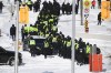 A lineup of police officers assemble on Colonel By Drive near the truck blockade in Ottawa, on Friday, Feb. 18, 2022. Senior federal civil servants are testifying or the first time at the commission investigating the federal government's invocation of the Emergencies Act last winter. THE CANADIAN PRESS/Justin Tang