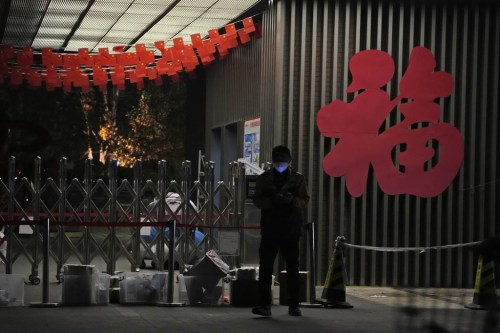 A delivery man checks his phone after leaving his deliveries outside an old folks home decorated with the word 