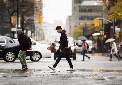People cross the road in downtown Toronto on Friday, Nov. 2, 2018. Since the global onset of COVID-19, Canada has been gradually closing the gap with the United States when it comes to attracting and keeping an important economic prize: new permanent residents. THE CANADIAN PRESS/Nathan Denette