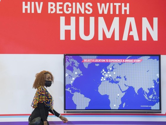 A woman walks by a sign during the AIDS 2022 conference in July. (Graham Hughes / The Canadian Press files)