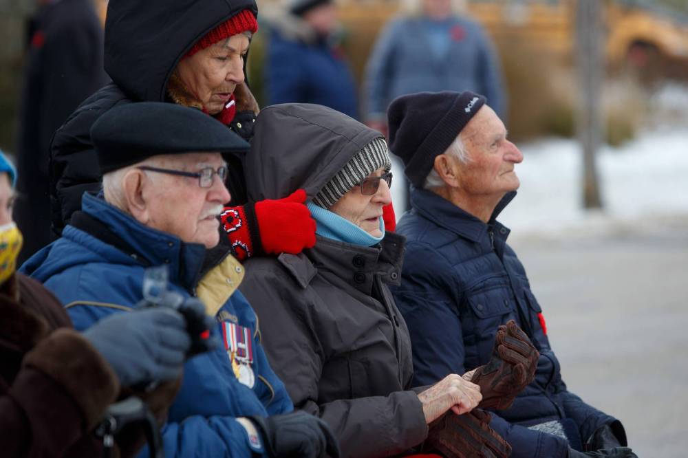 MIKE DEAL / WINNIPEG FREE PRESS
Tova Anderson adjusts Stephen Andrushko’s hood while fellow WWII veterans Robert Bullen (left) and Peter Frejuk (right) wait for the start of the No Stone Left Alone ceremony.