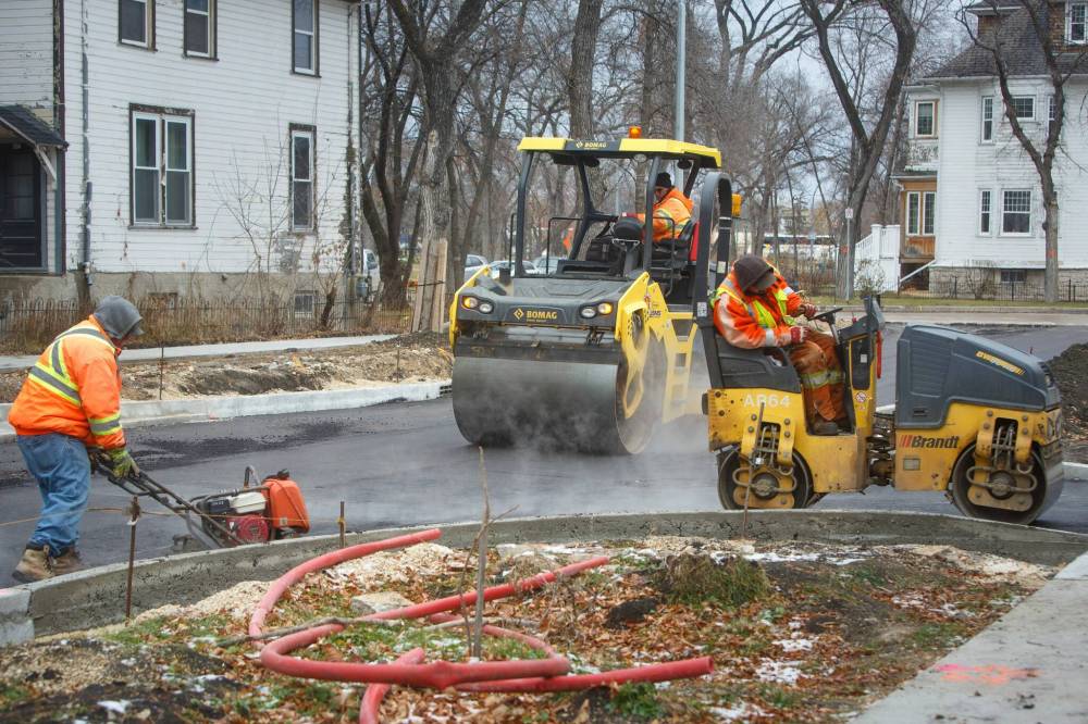 A construction crew lays asphalt on Canora Street on Tuesday. (Mike Deal / Winnipeg Free Press)