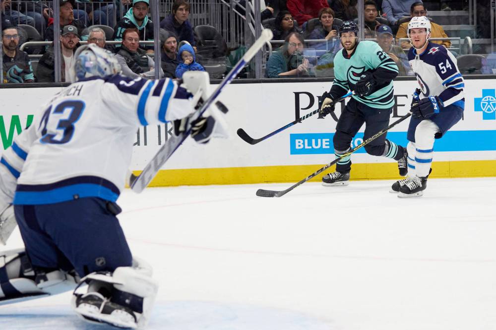 JOHN FROSCHAUER / THE ASSOCIATED PRESS
Seattle Kraken right wing Oliver Bjorkstrand (22) watches his shot on goal with Winnipeg Jets defenseman Dylan Samberg (54) during the first period.