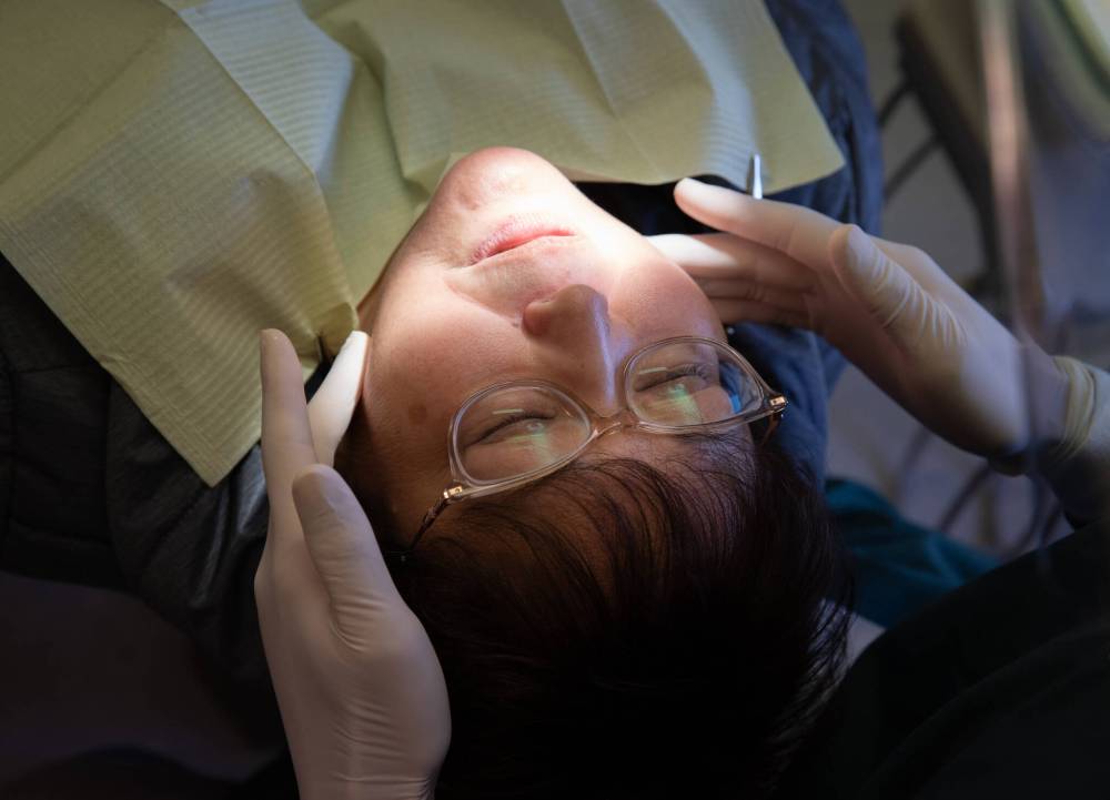 JESSICA LEE / WINNIPEG FREE PRESS
After taking X-rays of Wolfe’s mouth, Mah works to find the reason behind her tooth pain.