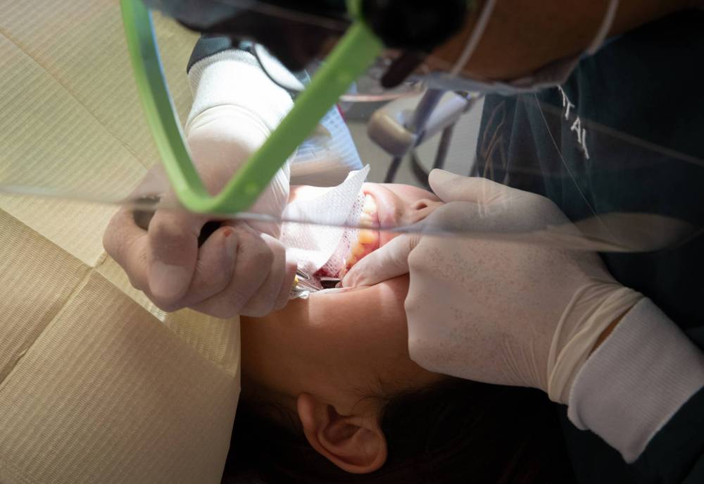 JESSICA LEE / WINNIPEG FREE PRESS
Mah pulls out Monica’s tooth after she complains of a pain.