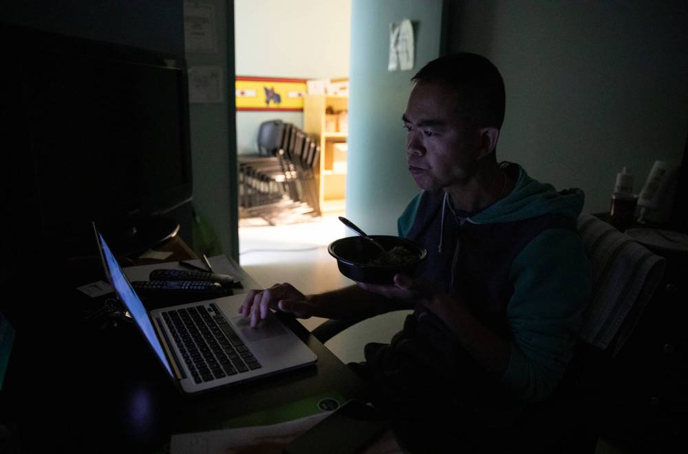 JESSICA LEE / WINNIPEG FREE PRESS
After the community loses power, Mah spends the rest of the evening eating in the dark and replying to emails. He had prepared his dinner before going out, so his dinner was warm and ready.