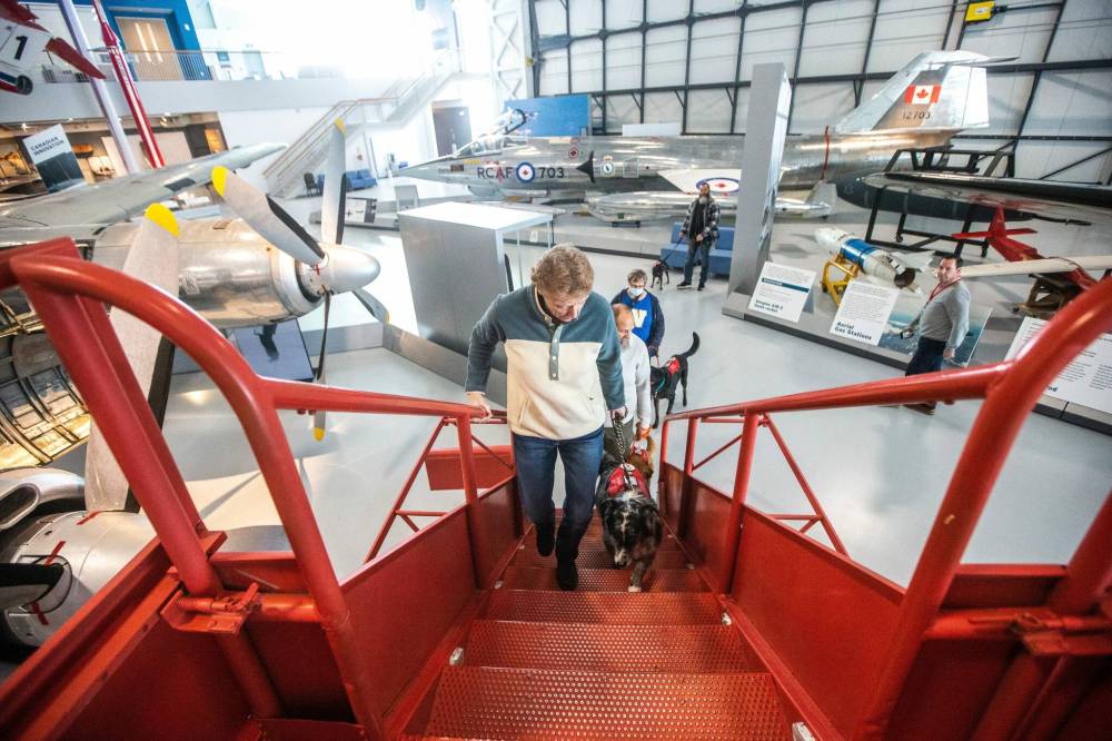 MIKAELA MACKENZIE / WINNIPEG FREE PRESS
Kelly Russell, founder of K9RR Service Dog Academy, leads a group of veterans and their therapy dogs around the Royal Aviation Museum of Western Canada.The dogs must get used to all manner of sounds and distractions. The cavernous museum, with its large planes ‘was a great training exercise for them,’ says Russell.