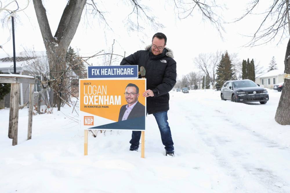 RUTH BONNEVILLE / WINNIPEG FREE PRESS
NDP candidate Logan Oxenham puts up a sign on supporter’s property on Aldine street for the upcoming Kirkfield park byelection.
