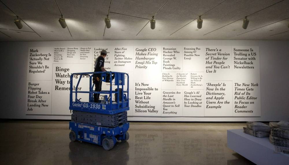 MIKE DEAL / WINNIPEG FREE PRESS
An installation technician adjusts the lights in front of Ron Terada’s large piece titled, TL; DR 2.