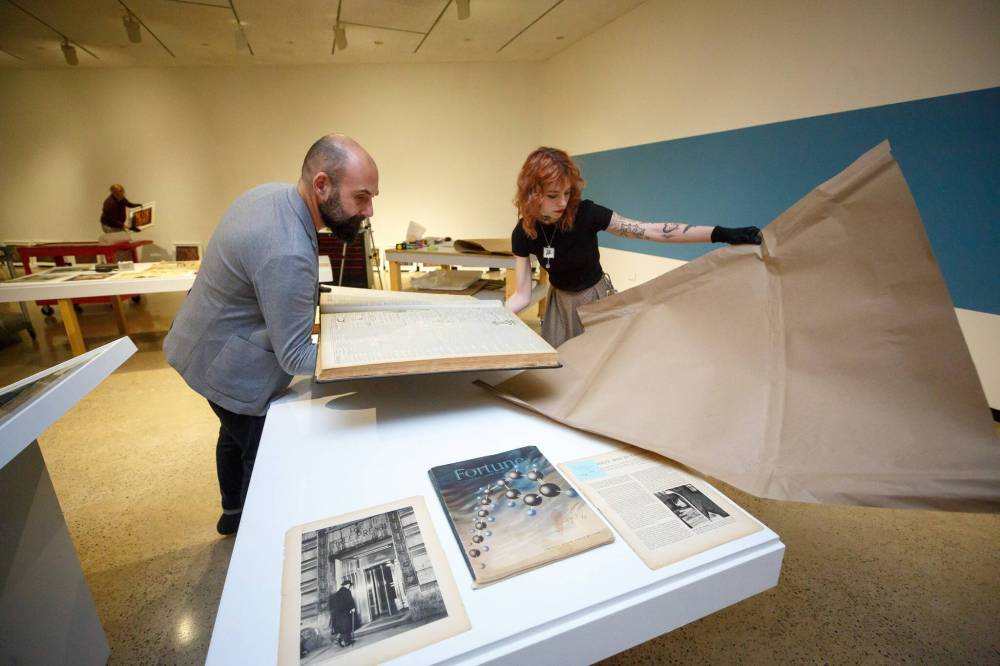 MIKE DEAL / WINNIPEG FREE PRESS
Radovan Radulovic (left), head of visitor and museum services, and installation technician Adelle Rawluk with bound copies of old Free Press editions.