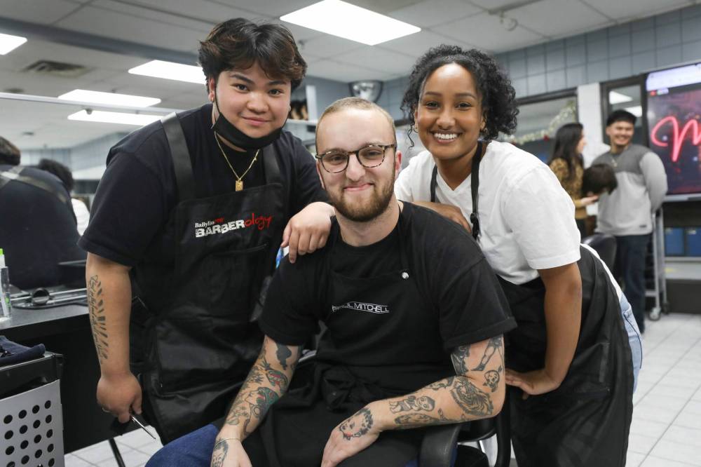 MITT students Betty Lakew (right), Luke Chafe (centre) and Gabriel Garcia took part in the cut-a-thon for the Christmas Cheer Board on Wednesday. (Ruth Bonneville / Winnipeg Free Press)