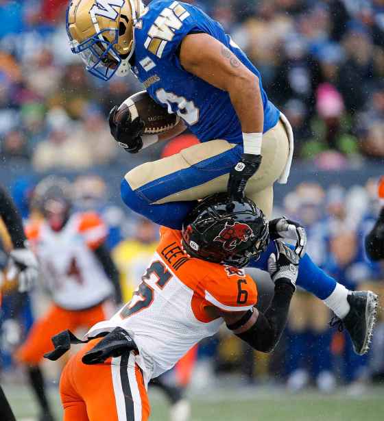 Nic Demski makes his way over BC Lions T.J. Lee as he runs for the first down during the first half of the CFL western final in Winnipeg, Sunday. (John Woods / The Canadian Press files)