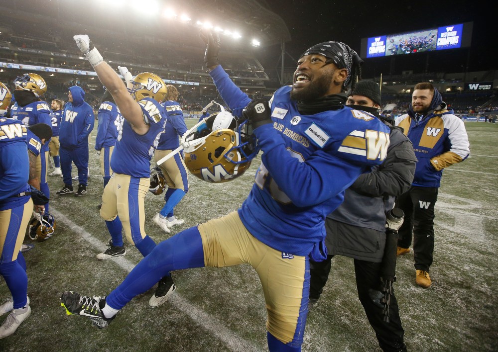 JOHN WOODS / THE CANADIAN PRESS
Winnipeg Blue Bombers' Cameron Lawson (99) and Desmond Lawrence (46) celebrate defeating the BC Lions.