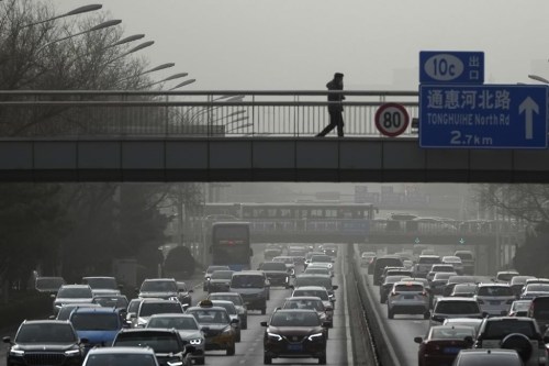 Vehicles move on a city highway in Beijing, Monday, Dec. 12, 2022, as capital city is hit by sandstorm. China will drop a travel tracing requirement as part of an uncertain exit from its strict 