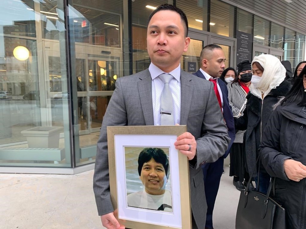 Edward Balaquit holds a picture of his father, Eduardo Balaquit, outside the Winnipeg Law Courts on Wednesday Nov. 9, 2022. A man found guilty of manslaughter in the death of Eduardo Balaquit has been sentenced to 16 years in prison. THE CANADIAN PRESS/Brittany Hobson