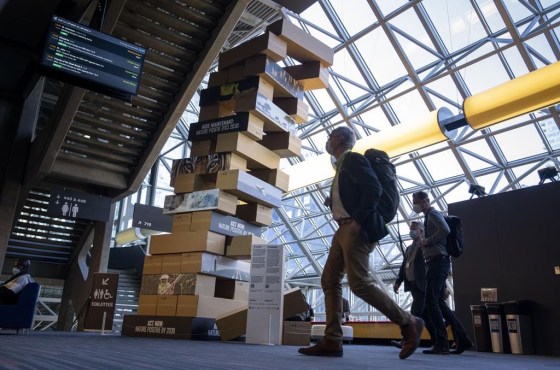 Delegates walk past a giant Jenga-style tower at the COP15 United Nations conference on biodiversity in Montreal. (Paul Chiasson / The Canadian Press files)