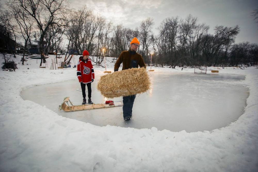 JOHN WOODS / WINNIPEG FREE PRESS
Eric Reder and his son North, 14, get their skating rinks on the Seine River ready for the winter season.