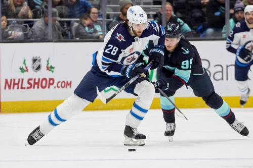JOHN FROSCHAUER / THE ASSOCIATED PRESS
                                Winnipeg Jets center Kevin Stenlund (28) and Seattle Kraken left wing Andre Burakovsky (95) vie for the puck during the third period of an NHL hockey game, Sunday, Dec. 18, 2022, in Seattle.