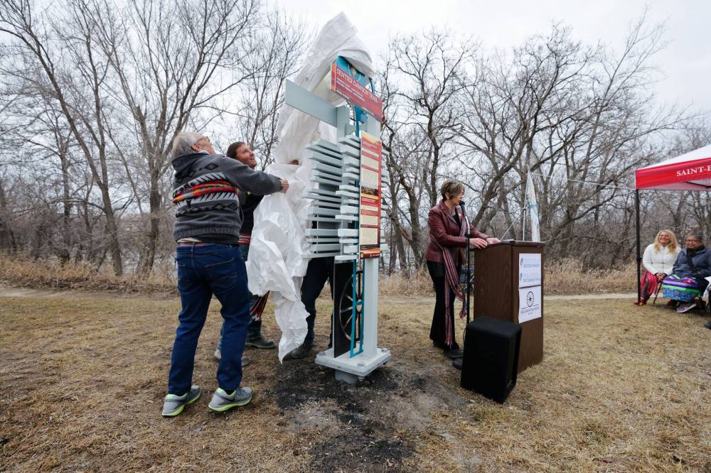 RUTH BONNEVILLE / WINNIPEG FREE PRESS
Pierrette Sherwood, chairwoman of Dawson Trail Arts and Heritage Tour, along with supporters, takes part in the unveiling of an interpretive landmark on the western terminus of the trail at the Seine River Parkway.