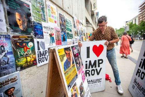 MIKAELA MACKENZIE PHOTOS / WINNIPEG FREE PRESS
                                Stephen Sim puts out a new sandwich board at the Royal Manitoba Theatre Company.