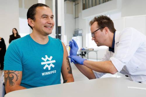 (Mike Deal / Winnipeg Free Press)
                                Premier Wab Kinew receives his COVID-19 and flu vaccines from Adrian Gulowaty, pharmacist at the Shoppers Drug Mart in Osborne Village.