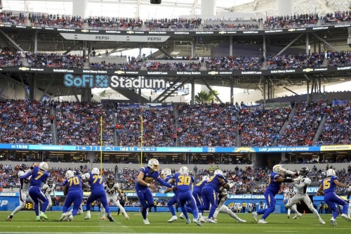 Los Angeles Chargers quarterback Justin Herbert (10) hands the ball to running back Austin Ekeler (30) during the first half of an NFL football game against the Denver Broncos Sunday, Dec. 10, 2023, in Inglewood, Calif. (AP Photo/Marcio Jose Sanchez)