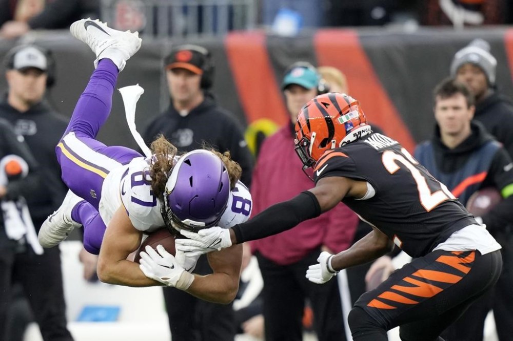 Minnesota Vikings tight end T.J. Hockenson (87) makes a catch next to Cincinnati Bengals cornerback Mike Hilton (21) during overtime of an NFL football game Saturday, Dec. 16, 2023, in Cincinnati. (AP Photo/Carolyn Kaster)