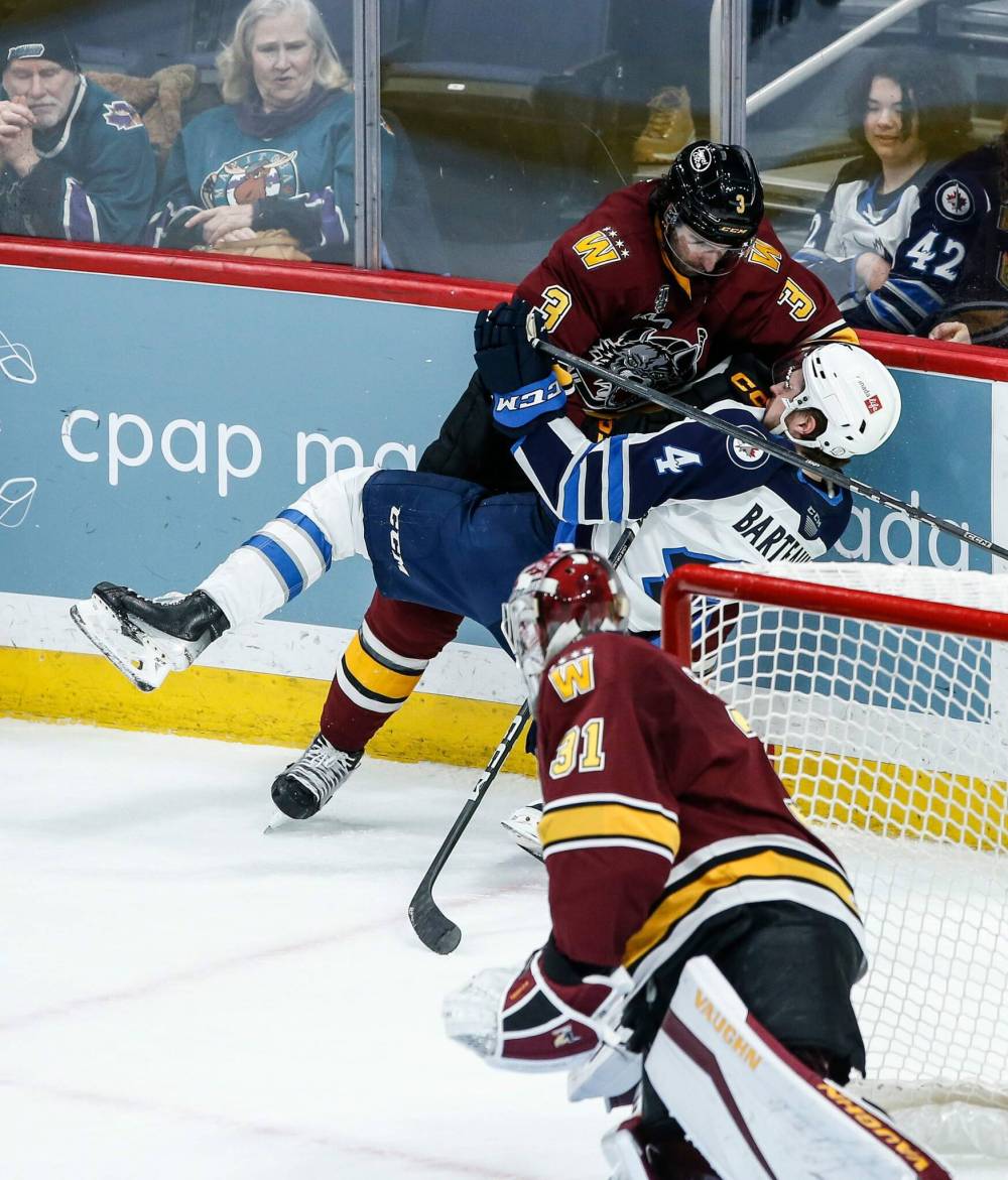 JOHN WOODS / WINNIPEG FREE PRESS
Chicago Wolves’ Tory Dello gives Manitoba Moose Dawson Barteaux a rough ride as goaltender Adam Scheel looks on during the first period.
