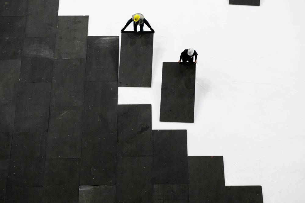 MIKE SUDOMA / FREE PRESS Crew members prepare the floor at Canada Life centre as they convert the stadium from a hockey rink over to a music venue early Wednesday morning Nov 13, 2024