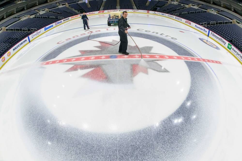 MIKE SUDOMA / FREE PRESS
David Wright (right) paints the ice surface at centre ice white to prepare for Disney on Ice coming up this weekend Nov 11, 2024