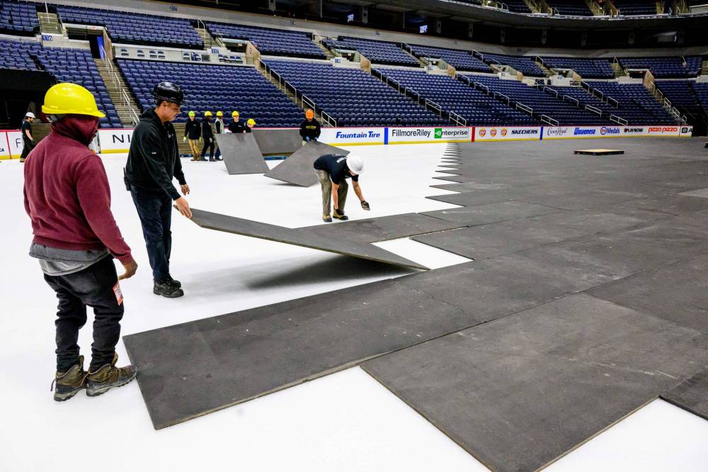 MIKE SUDOMA / FREE PRESS Crew members prepare the floor at Canada Life centre as they convert the stadium from a hockey rink over to a music venue early Wednesday morning Nov 13, 2024