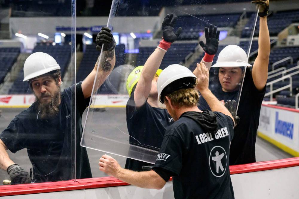 MIKE SUDOMA / FREE PRESS
It’s all hands on deck (and on the glass) as safety is paramount during rink conversion.
