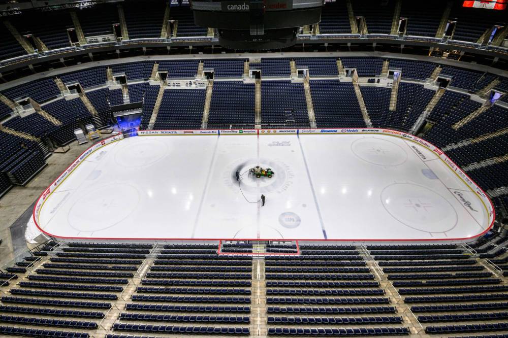MIKE SUDOMA / FREE PRESS
Engineers Ryan Jones (left) and David Wright paint the Canada Life Centre ice surface white in advance of this weekend’s Disney on Ice shows. The ice was then covered up to prepare for Bruce Springsteen’s concert.