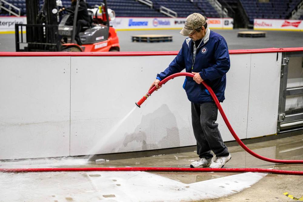 MIKE SUDOMA / FREE PRESS
Lloyd Cook melts ice outside the boards prior to their removal.