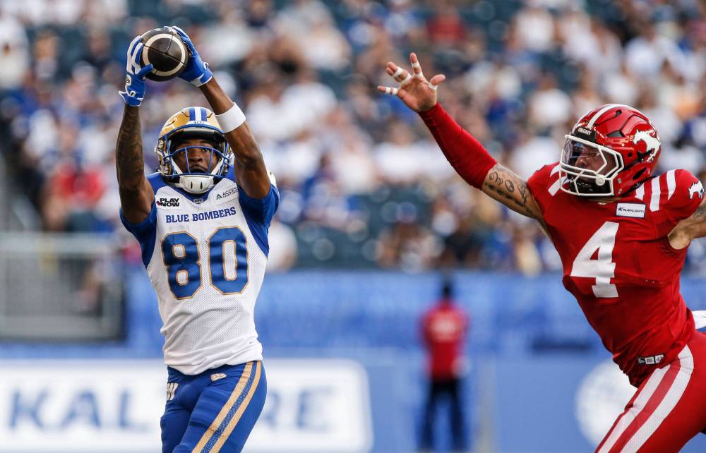 THE CANADIAN PRESS/John Woods
Winnipeg Blue Bombers’ Ontaria Wilson (80) catches his pass against Calgary Stampeders’ Cameron Judge (4) during first half CFL action in Winnipeg, Friday, July 12, 2024.