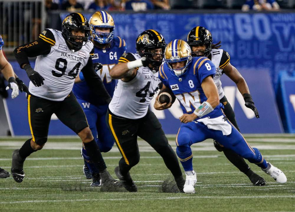 THE CANADIAN PRESS/John Woods
Winnipeg Blue Bombers quarterback Zach Collaros (8) runs for the first down against the Hamilton Tiger-Cats during second half CFL action in Winnipeg Friday, August 23, 2024.