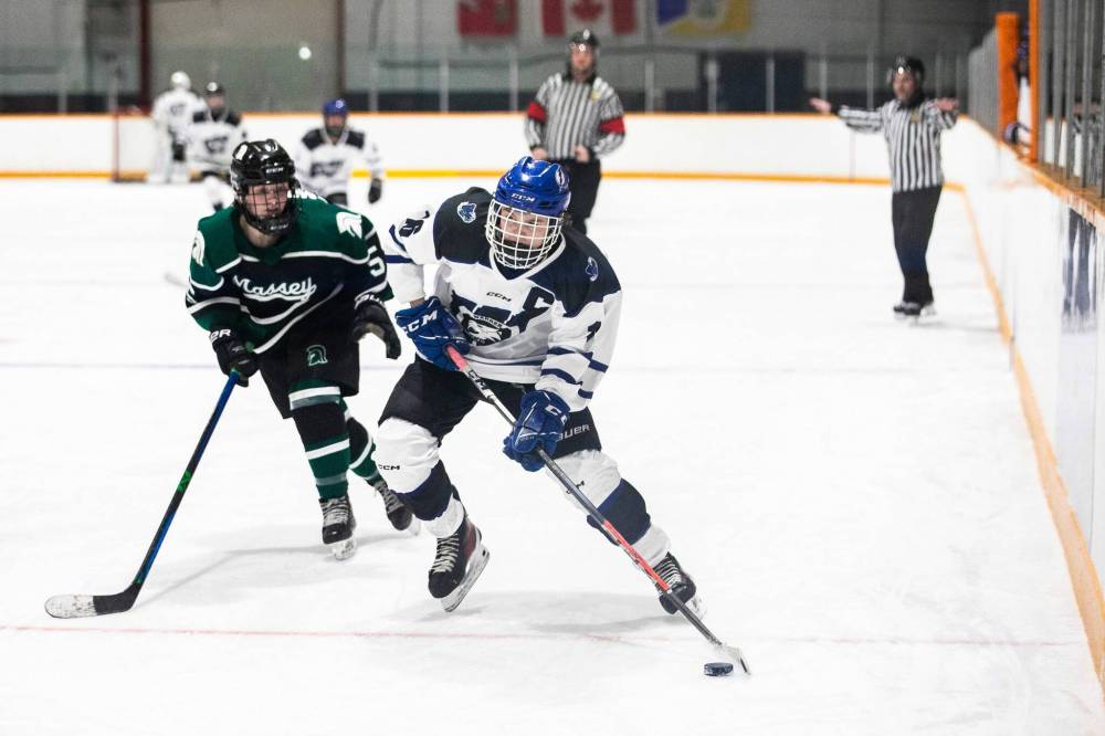 MIKAELA MACKENZIE / FREE PRESS
Warren Wildcats captain Bre-Ann Lucier Windross (right) and Vincent Massey Trojan Katelynn Motkaluk go for the puck during a game at the Century Arena.