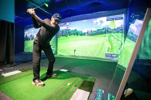 photos by MIKAELA MACKENZIE / FREE PRESS 
                                Darrin Stevenson plays a round Friday at Golf Square (106 Scurfield Blvd.). ‘Compared to outside (golf), it can show you more data,’ business owner June Kang says of the sensor-laden sport.