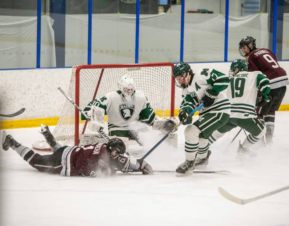 BROOK JONES/FREE PRESS
Vincent Massey goaltender Aapo Tuomine keeps an eye on the action while Massey blue-liner Rhett Forbest (right) and Westwood forward Gavin Salamacha (on ice) battle for the puck Wednesday at Seven Oaks Arena.