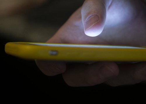 FILE - A man uses a cell phone in New Orleans on Aug. 11, 2019. (AP Photo/Jenny Kane, File)