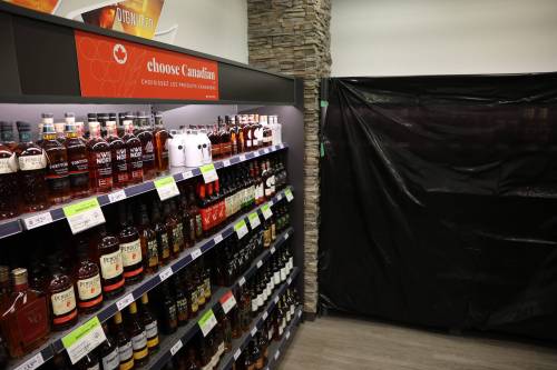 Canadian whisky is advertised at a Liquor Mart in March while black plastic covers the American whiskey section. (Tim Smith/The Brandon Sun files)