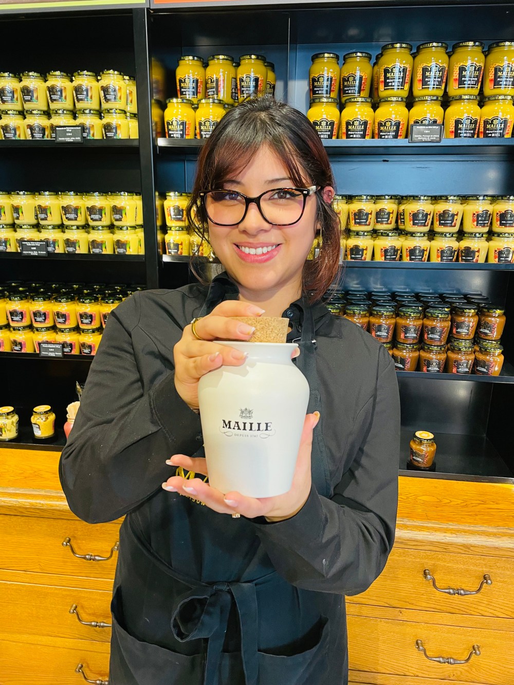 Shop clerk Fabia shows off the product at Moutarde Maille.